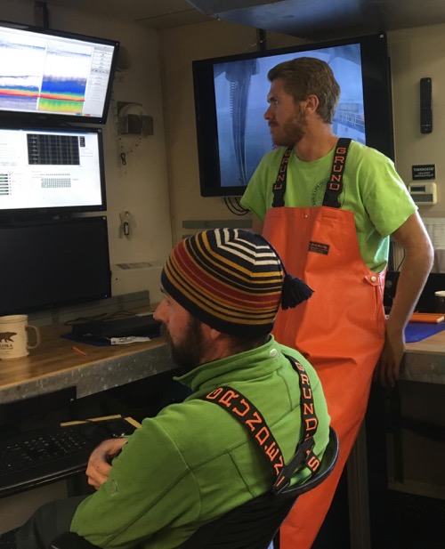 Joel Llopiz (left) and one of his PhD students, Justin Suca (right), viewing the data as their fish net is towed behing the R/V Sikuliaq.  September 2, 2017.  Photo by Lisa Seff.
