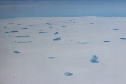Meltwater pools on the top of the ice sheet as seen from the LC-130.