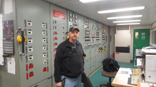J.P. Pierce, chief engineer in front of the control panel in the engine room.