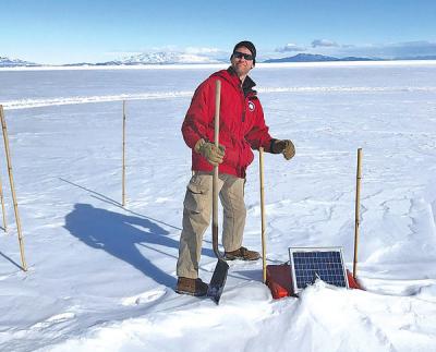Eric Thuma stands on the McMurdo Ice Sheet, preparing to extract a seismometer. (Photo provided by Dr. Doug MacAyeal)