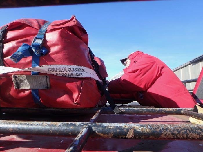 Two large red bags used for surviving in case we are stuck on the ice, are strapped down on top of the Pisten Bully.