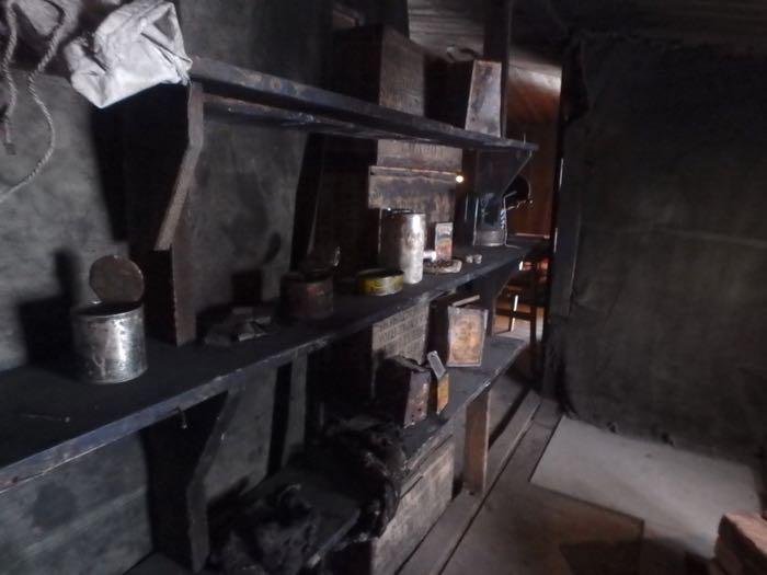Old cans, a stove, and even meat stacked on wodden shelves inside Scott's Discovery hut.