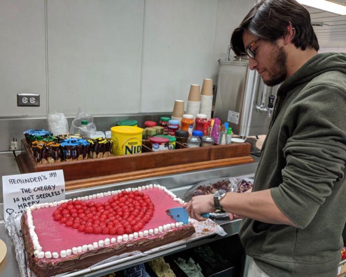 Grad student Santi Muneval cuts a piece of Valentine's Day cake