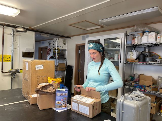 An image of Sarah in a lab with several boxes around her. 