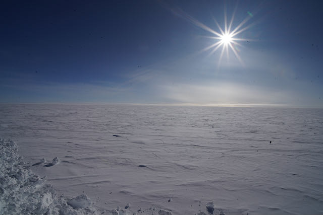 The sun over an expanse of white ice. 