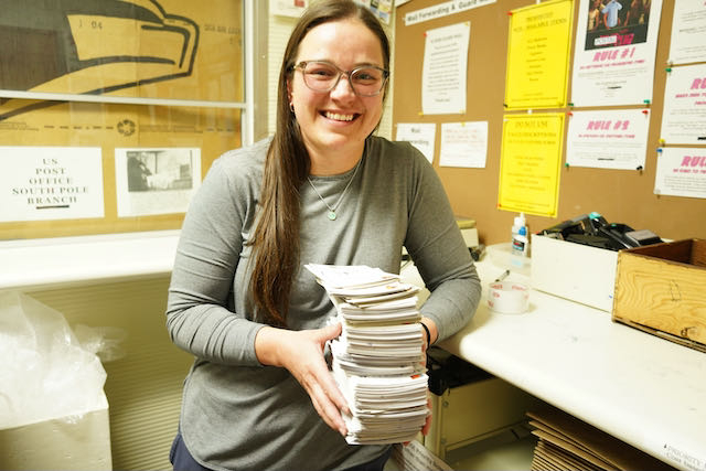 Elaine holds a stack of postcards