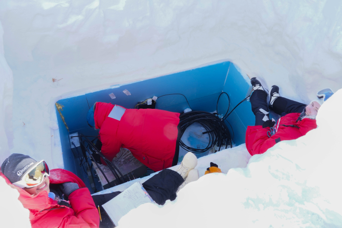 A group of scientists work in a hole in the ice
