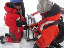 Arthi Ramachandran works on an ice core temperature measurement. On the sea ice near the CCGS Louis S. St-Laurent in the Beaufort Sea. Photo by Dave Jones (PolarTREC 2017), Courtesy of ARCUS.