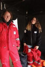 Two people wearing big red snowsuits