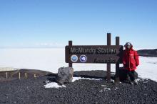 Elaine stands in front of the McMurdo Station, Antarctica sign