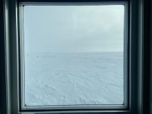 View out a window of the Ceremonial South Pole surrounded by flags
