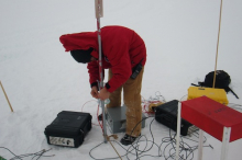 Sam checking up the data acquisition modules (DAQs) above an IceTop tank.