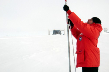 Me taking measurements of accumulated snow above an IceTop tank.