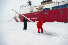 Paul Aguilar and Mark Stephens placing ice mass balance buoy in ice