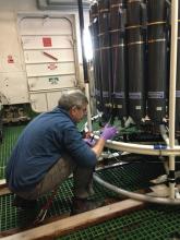 Dr. Bruce Huber is collecting water from the CTD for analysis.