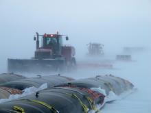 Tractors pulling fuel in a blizzard
