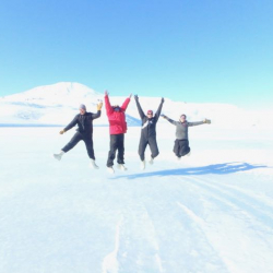 4 people jumping on the sea ice in Antarctica