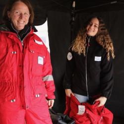 Two people wearing big red snowsuits