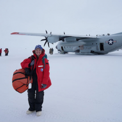 Elaine stands in front of an LC-130 on the snow runway