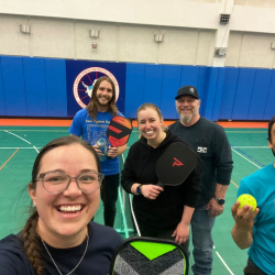 Five people standing in the South pole gymnasium with pickleball rackets