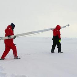 Paul Aguilar and Mark Stephens carrying ice mass balance buoy