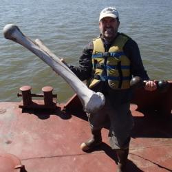 Mark does weight lifting on the barge – a mammoth femur and a dumbbell!